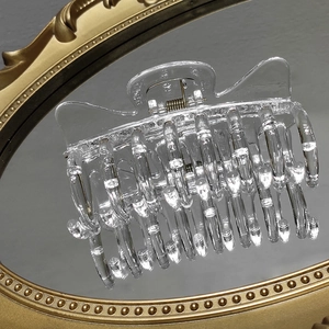 Detail of transparent cat ear hair claw clip with golden spring on vintage mirror