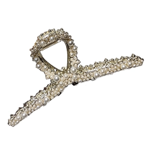 Elegant gold metal hair claw clip with multiple white pearls and a cross-spring design