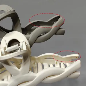 Close-up of matte claw clip mechanism with beige and olive green interlocking weave details
