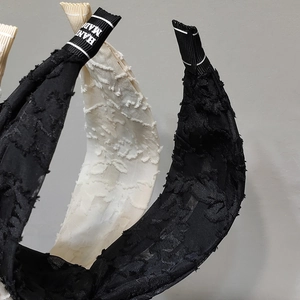 Close-up of vintage wide headband showing woven fabric texture and handmade label