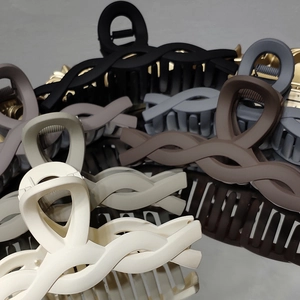 Close-up of large matte shark hair clips in a stacked variety of Morandi colors