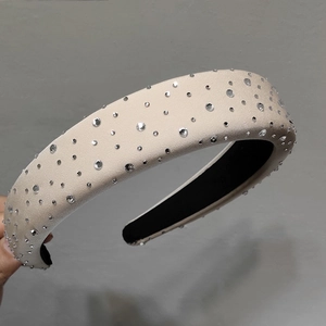 Détail d'un serre-tête rembourré beige orné de strass brillants avec doublure antidérapante