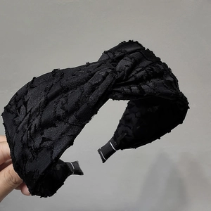 Detail of black wide knot headband with textured pleated fabric and protective ends
