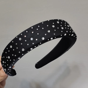 Gros plan sur un serre-tête noir rembourré orné de strass brillants à effet étoilé