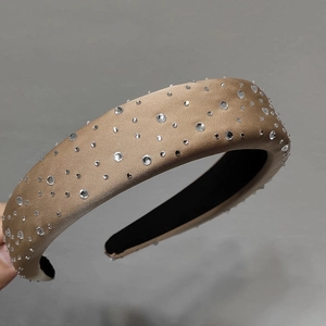 Détail du serre-tête en satin doré champagne avec strass brillants et éponge épaisse