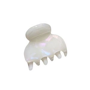 Dettaglio del fermaglio per capelli in acetato bianco perlato con riflessi cangianti