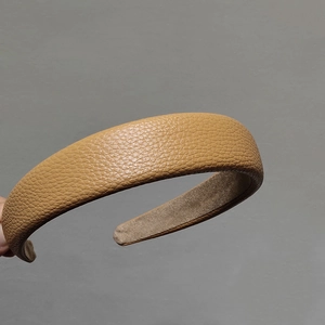 Vue détaillée du serre-tête en cuir marron clair avec texture grainée et doublure en velours