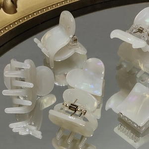Eleganti mollette per capelli iridescenti a forma di cuore e geometriche su superficie a specchio
