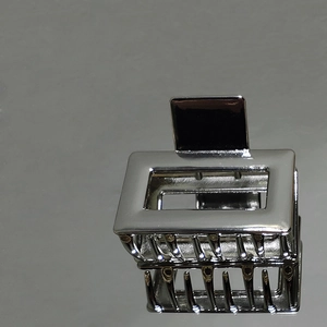 Detail view of square hollow metal hair claw clip in silver with polished finish