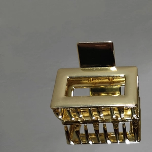 Close-up of a glossy gold rectangular hollow metal hair claw clip with a secure grip