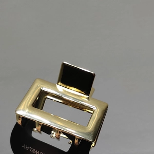 Minimalist square golden metal hair claw clip with hollow rectangular design on card
