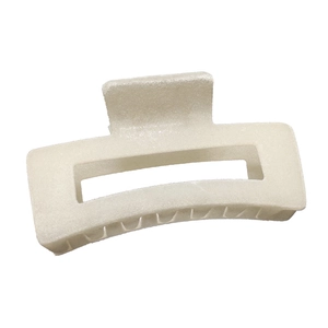 Close-up of matte cream hair claw clip with rectangular hollow design for styling