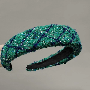 Close-up of green tweed headband with blue sequins and textured woven fabric