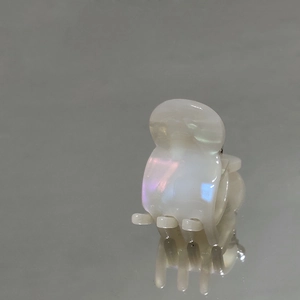 Dettaglio ravvicinato di una mini molletta per capelli con finitura perlata