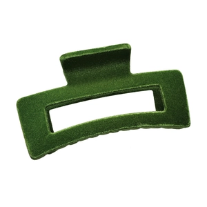 Detailed macro view of dark green flocked velvet hair claw clip with geometric hollow design
