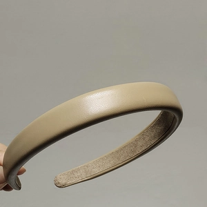 Detail view of beige sponge headband featuring lychee grain faux leather and non-slip lining