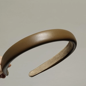 Detail of a brown leather sponge headband with non-slip suede lining and soft texture