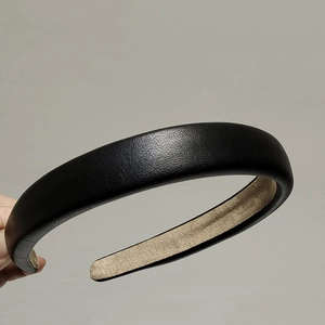 Detail of black faux leather headband with soft brown velvet lining and high top design