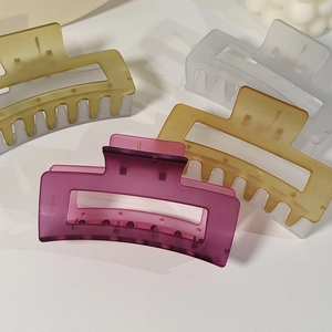 Detailed view of large matte hair claws in olive, white, yellow and rose red colors