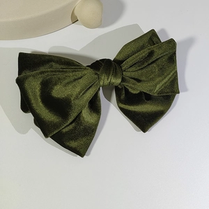 Detail of olive green velvet bow hair clip with vintage double-layer ruffled design