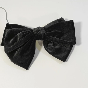 Detailed close-up of double-layered black velvet bow hair clip with soft texture