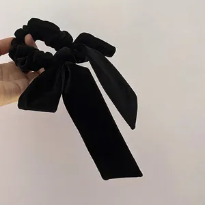 Elegant black velvet hair scrunchie with a long bow ribbon for women's hair styling