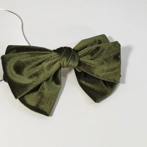 Detail view of the olive green velvet texture and classic bow design on the hair clip