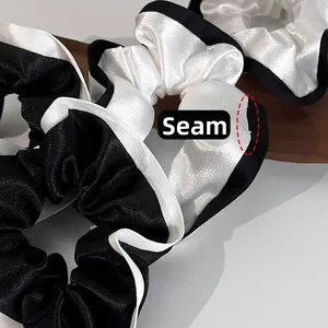 Gros plan sur la couture délicate et la texture satinée du chouchou noir et blanc