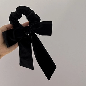 Close-up of elegant black velvet hair scrunchie with long ribbons and bow detail