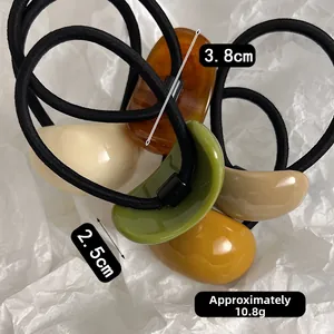 Detail view of five bean-shaped resin hair ties in earthy tones with size dimensions