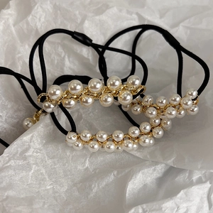 Eleganter Perlhaargummi mit goldener Kette auf einem hochelastischen schwarzen Band