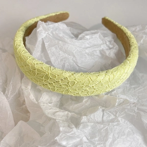 Detailed view of yellow crochet lace headband with non-slip khaki suede lining texture