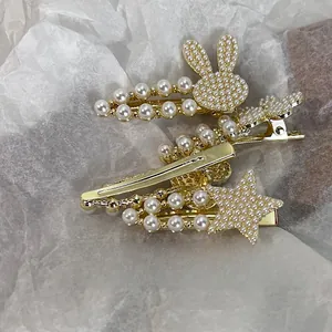 Détail de barrettes dorées en forme de lapin et d'étoile avec perles incrustées