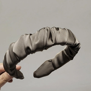 Elegant chocolate brown pleated wide headband in silky satin fabric held by hand