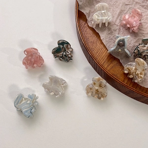Detailed close-up of colorful marble pattern acetate hair claws in various vibrant shades