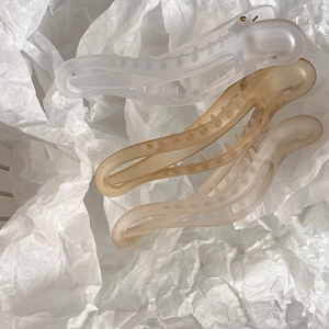 Three-piece matte banana hair clips in transparent white, amber, and soft pink tones