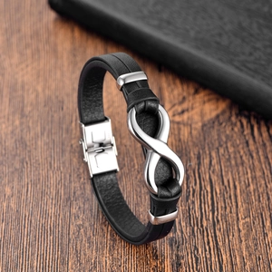 Men's black braided leather bracelet with silver infinity symbol on a wooden surface