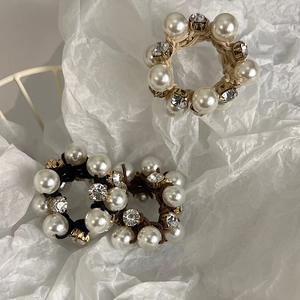 Detailed view of elegant pearl hair ties with sparkling rhinestones in three colors