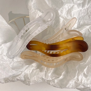 Detail of matte hair claws in neutral tones with anti-slip design and sleek cut-out style