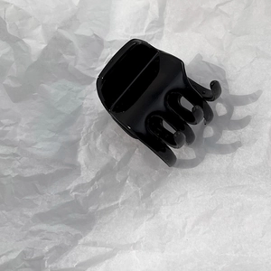 Close-up of a glossy black minimalist hair claw clip for high ponytail styling and support