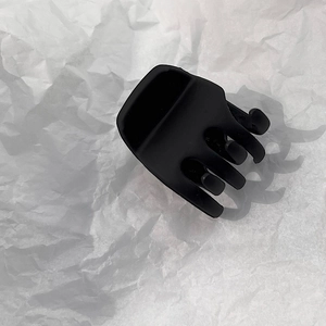 Detail of matte black hair claw clip featuring a five-tooth grip design and frosted texture