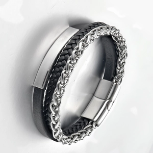 Macro detail van meerlaagse zwarte lederen armband met gevlochten stalen ketting en magneetsluiting