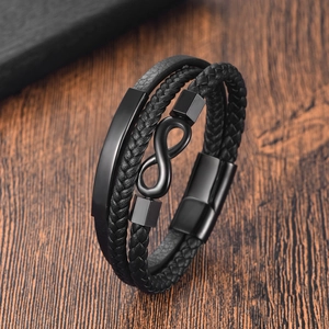 Men's black braided leather infinity bracelet with metallic magnetic clasp on dark wood