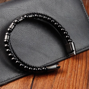 Detail of men's double-layer braided leather bracelet with black beads and metal clasp