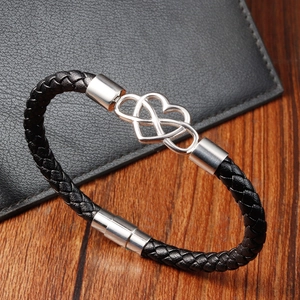 Detail of infinity heart charm on braided leather bracelet with magnetic clasp
