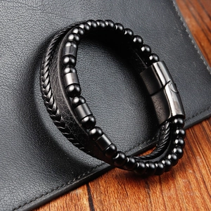 Close-up of black braided leather bracelet for men with metal beads and magnetic clasp