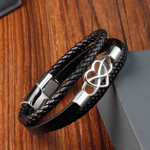 Detail of black multi-layer braided leather bracelet with silver infinity heart charm