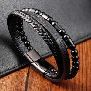 Close-up of multilayer black braided leather bracelet with matte metal beads and magnetic clasp