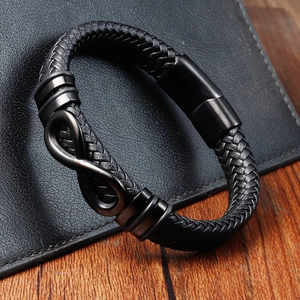 Dettaglio del bracciale da uomo in pelle nera intrecciata con segno infinito e chiusura magnetica