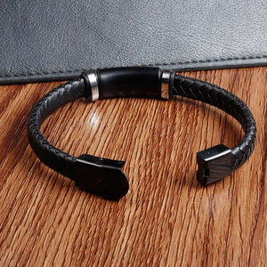 Detailansicht eines geflochtenen Lederarmbands für Herren mit Metallplatte und Steckverschluss